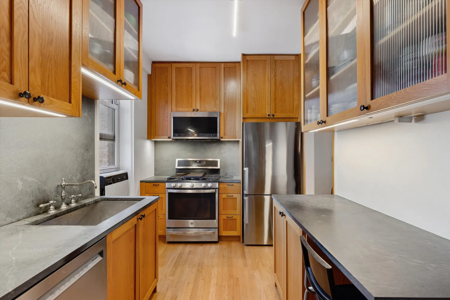 a kitchen with stainless steel appliances granite countertop a stove a sink and a refrigerator