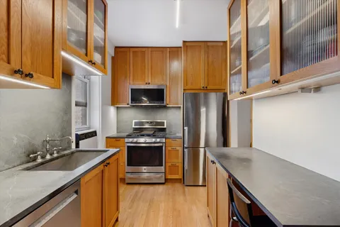 a kitchen with stainless steel appliances granite countertop a stove a sink and a refrigerator