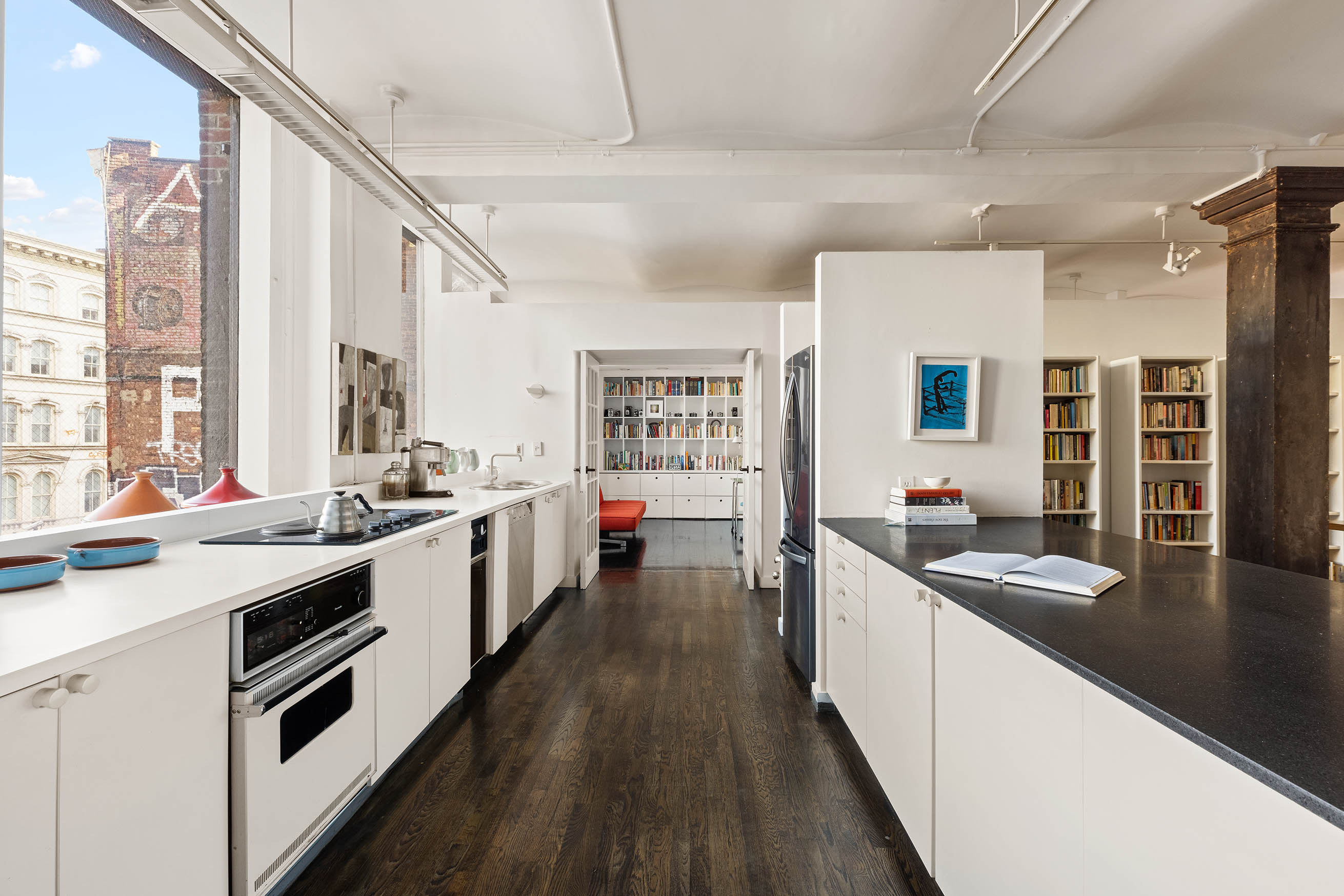 45 Lispenard Street, Unit 3E Manhattan, NY 10013 - Photo 4 of 13 a large kitchen with stainless steel appliances granite countertop a lot of counter space and wooden floors