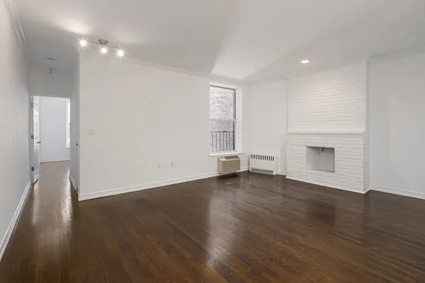 an empty room with wooden floor and a window