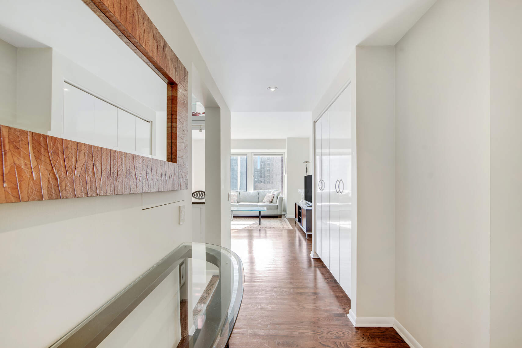 150 West 56th Street, Unit 3812 Manhattan, NY 10019 - Photo 8 of 14 a view of a hallway with wooden floor and furniture