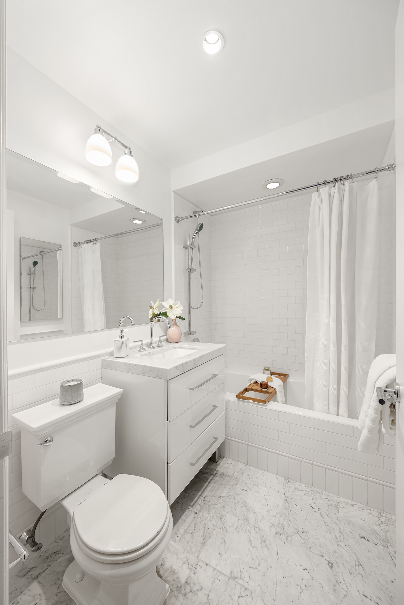 43 West 64th Street, Unit 7A Manhattan, NY 10023 - Photo 17 of 20 a bathroom with a toilet sink vanity and mirror