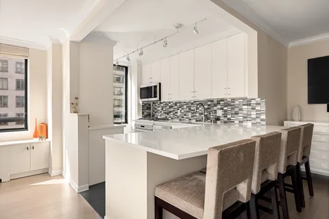 a kitchen with stainless steel appliances kitchen island granite countertop a table and chairs