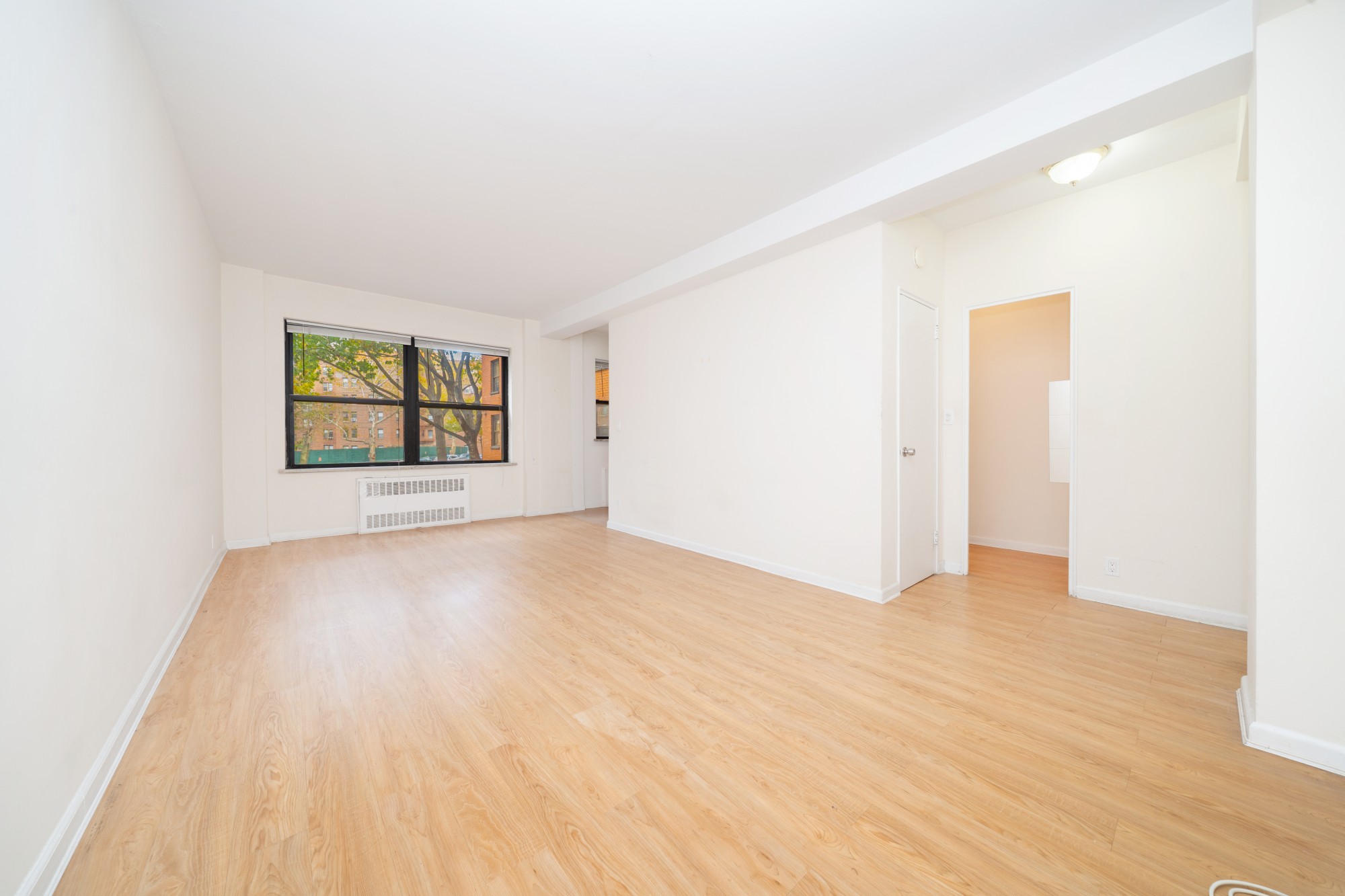 99-52 66th Road, Unit 1H Queens, NY 11374 - Photo 3 of 11 an empty room with windows and closet