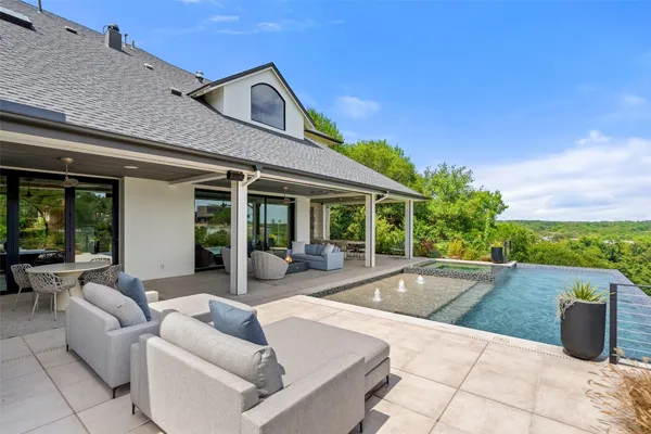 a view of a patio with couches and table and chairs with wooden fence
