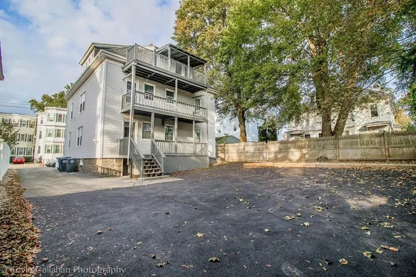 a view of a house with a yard and large trees