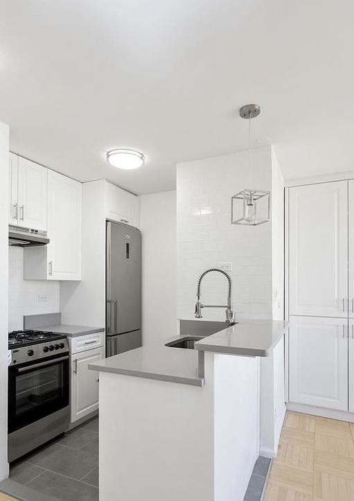 330 East 38th Street, Unit 38I Manhattan, NY 10016 - Photo 9 of 17 a kitchen with stainless steel appliances granite countertop a sink stove and refrigerator