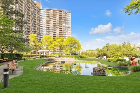 a view of a swimming pool with lawn chairs and a big yard