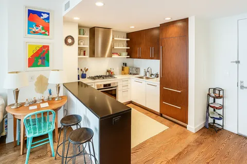 a kitchen with stainless steel appliances granite countertop a stove a refrigerator and a dining table