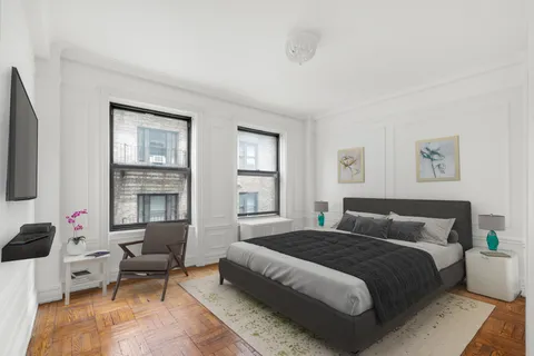 a bedroom with a bed and wooden floor