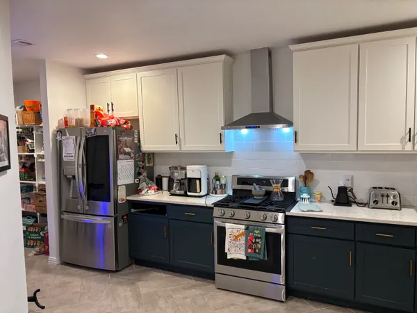 a kitchen with stainless steel appliances granite countertop a stove a sink and a refrigerator