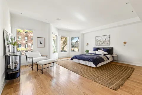 a spacious bedroom with a bed a couch and a window