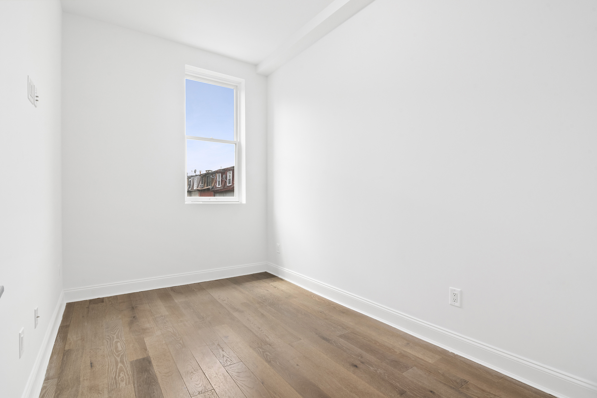 467 Tompkins Avenue, Unit 3A Brooklyn, NY 11216 - Photo 9 of 12 a view of an empty room with wooden floor and a window