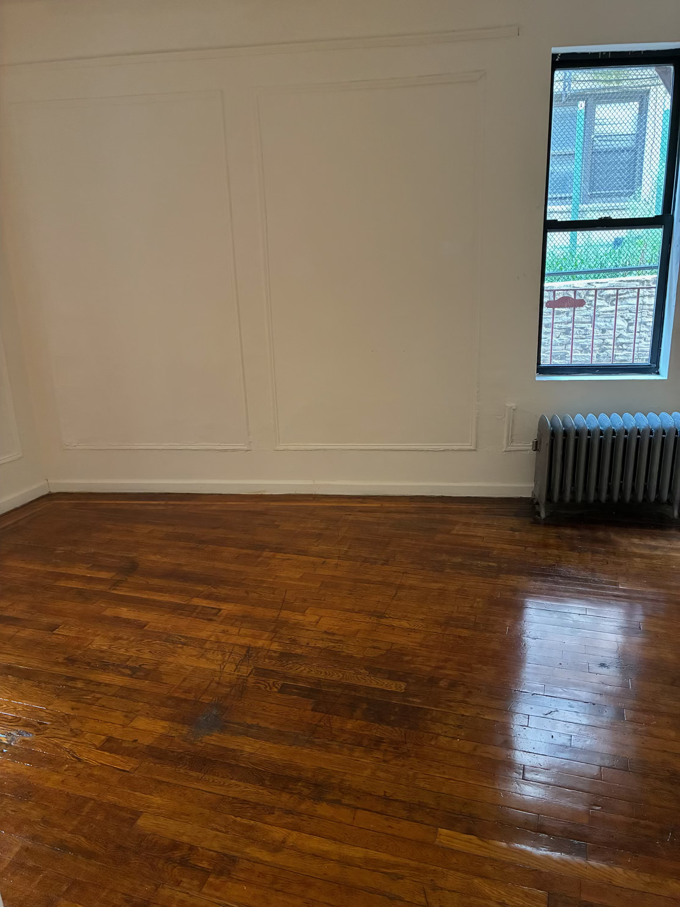 2755 Reservoir Avenue, Unit 1F Bronx, NY 10468 - Photo 3 of 5 an empty room with wooden floor and windows