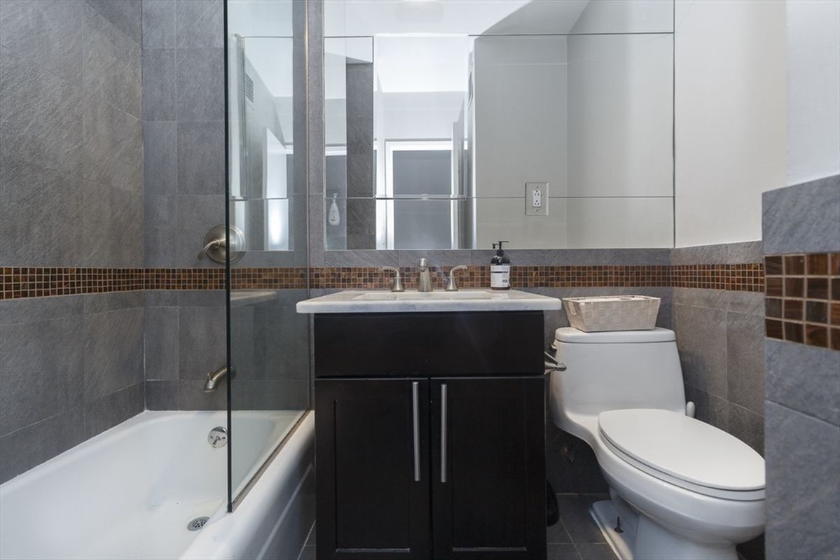 315 7th Avenue, Unit 6A Manhattan, NY 10001 - Photo 6 of 10 a bathroom with a sink a toilet and bathtub