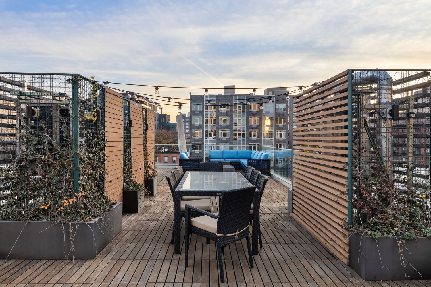 a view of a roof deck with table and chairs and wooden floor