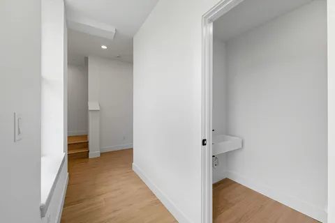 a view of a hallway with wooden floor and entryway