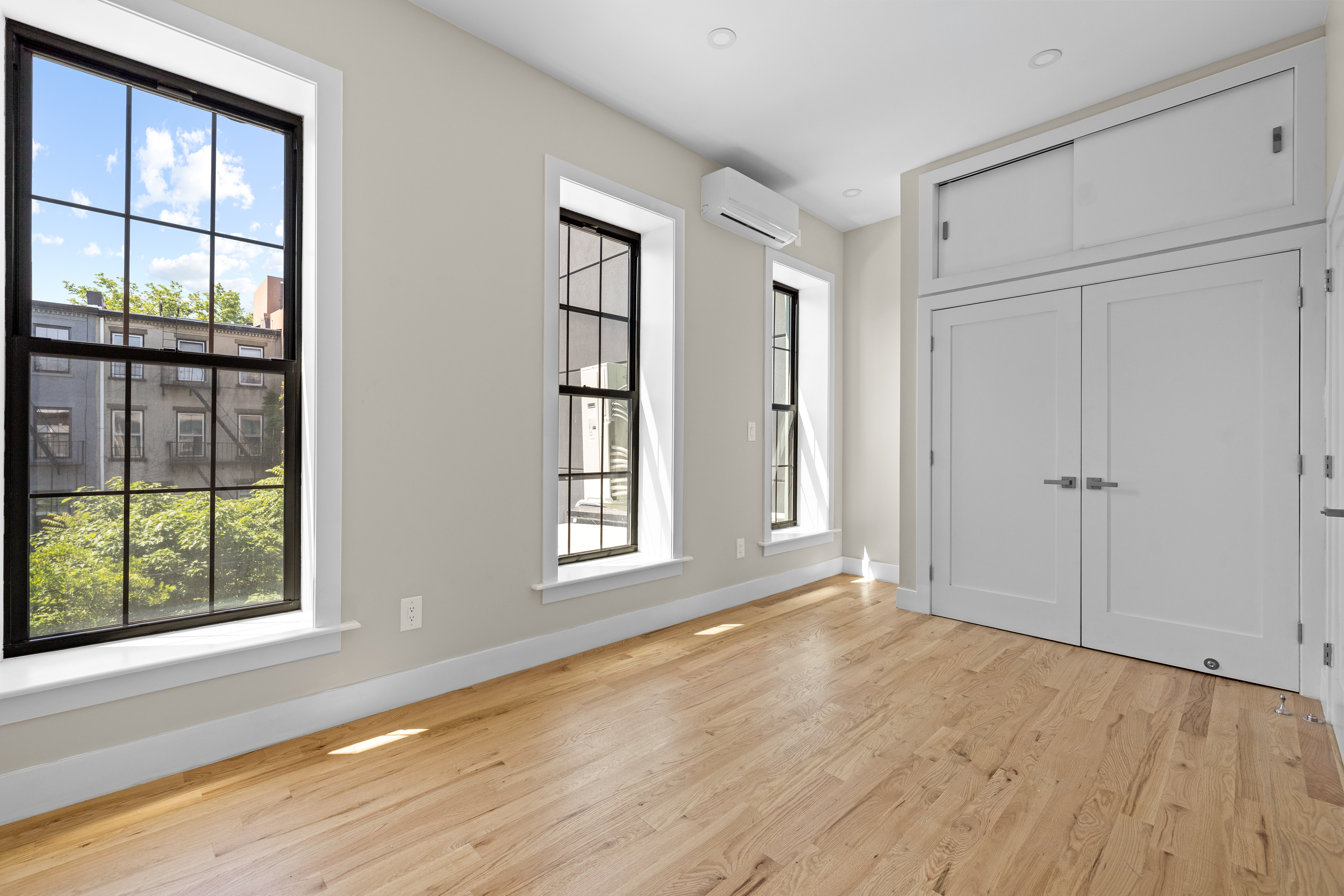 456 Willoughby Avenue, Unit 1 Brooklyn, NY 11206 - Photo 7 of 14 an empty room with wooden floor and windows