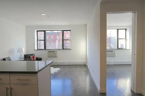 a kitchen with a sink a window and wooden floor