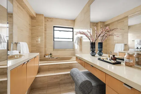 a bathroom with a tub sink and mirror