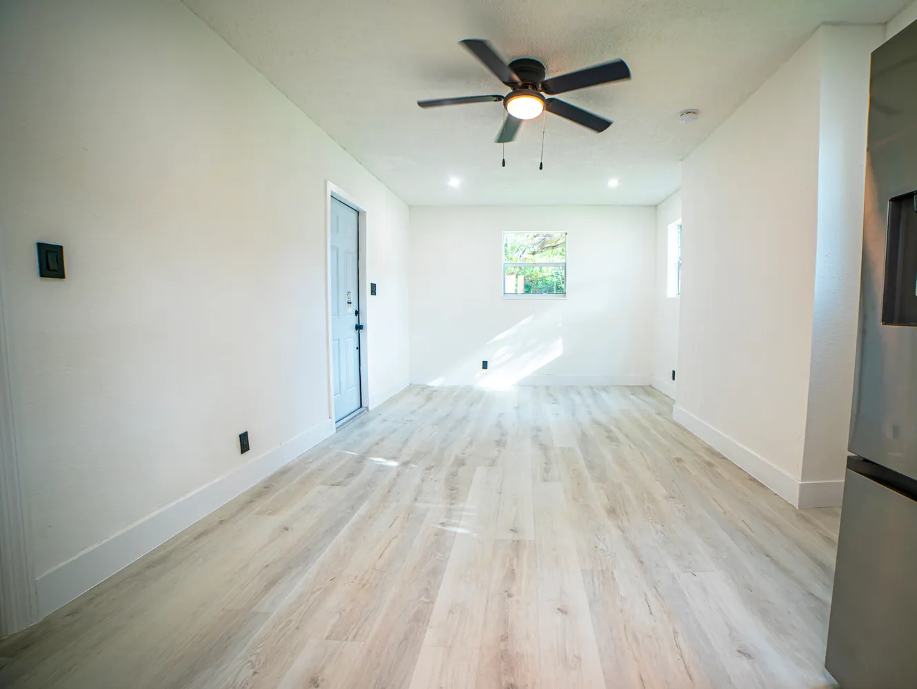 a view of empty room with wooden floor