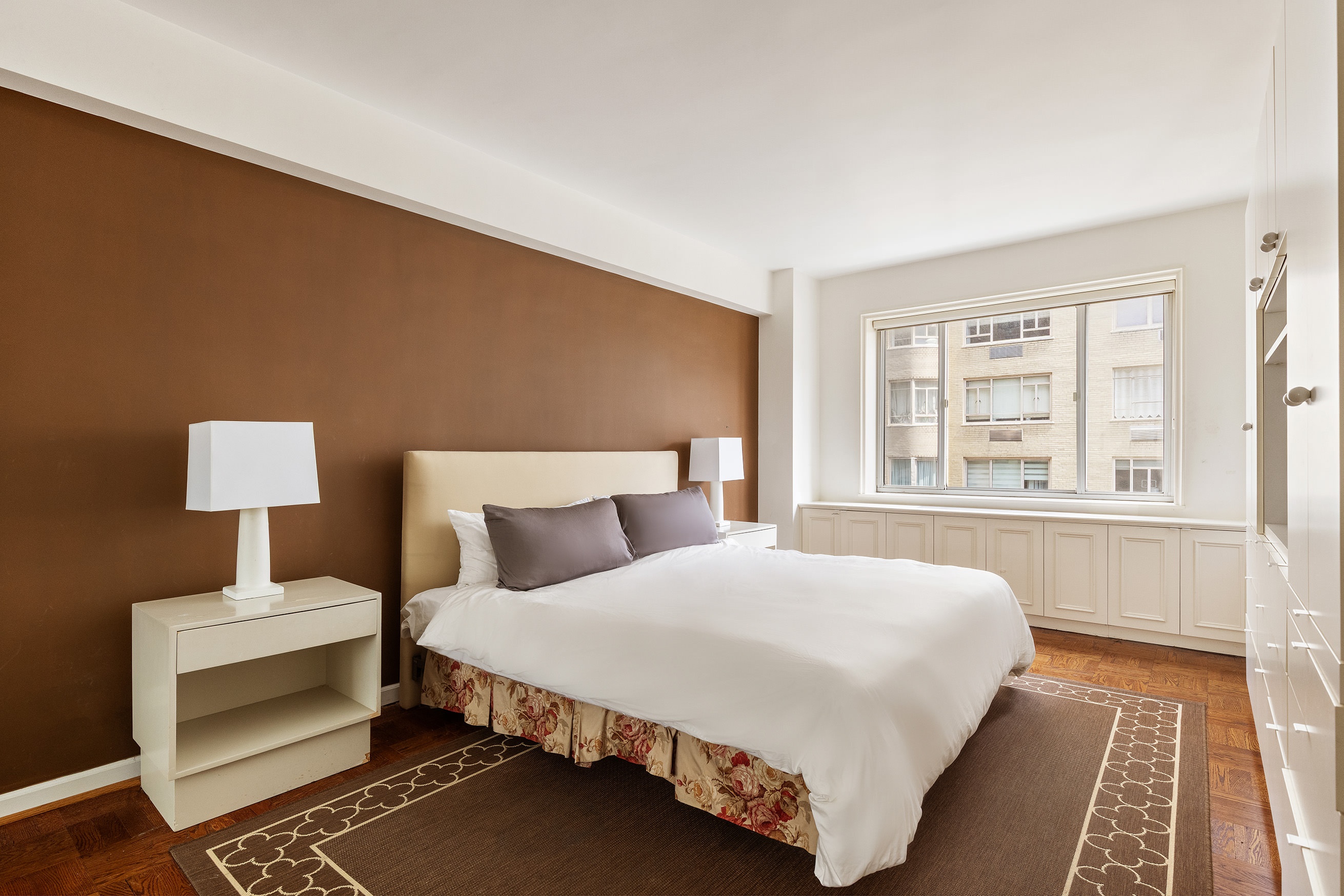 860 5th Avenue, Unit 11E Manhattan, NY 10065 - Photo 6 of 9 a bedroom with a bed lamp and a large window with wooden floor