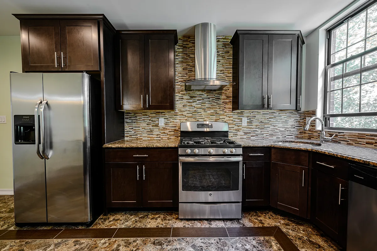 877 Greene Avenue, Unit 2 Brooklyn, NY 11221 - Photo 8 of 13 a kitchen with stainless steel appliances granite countertop a refrigerator and a sink