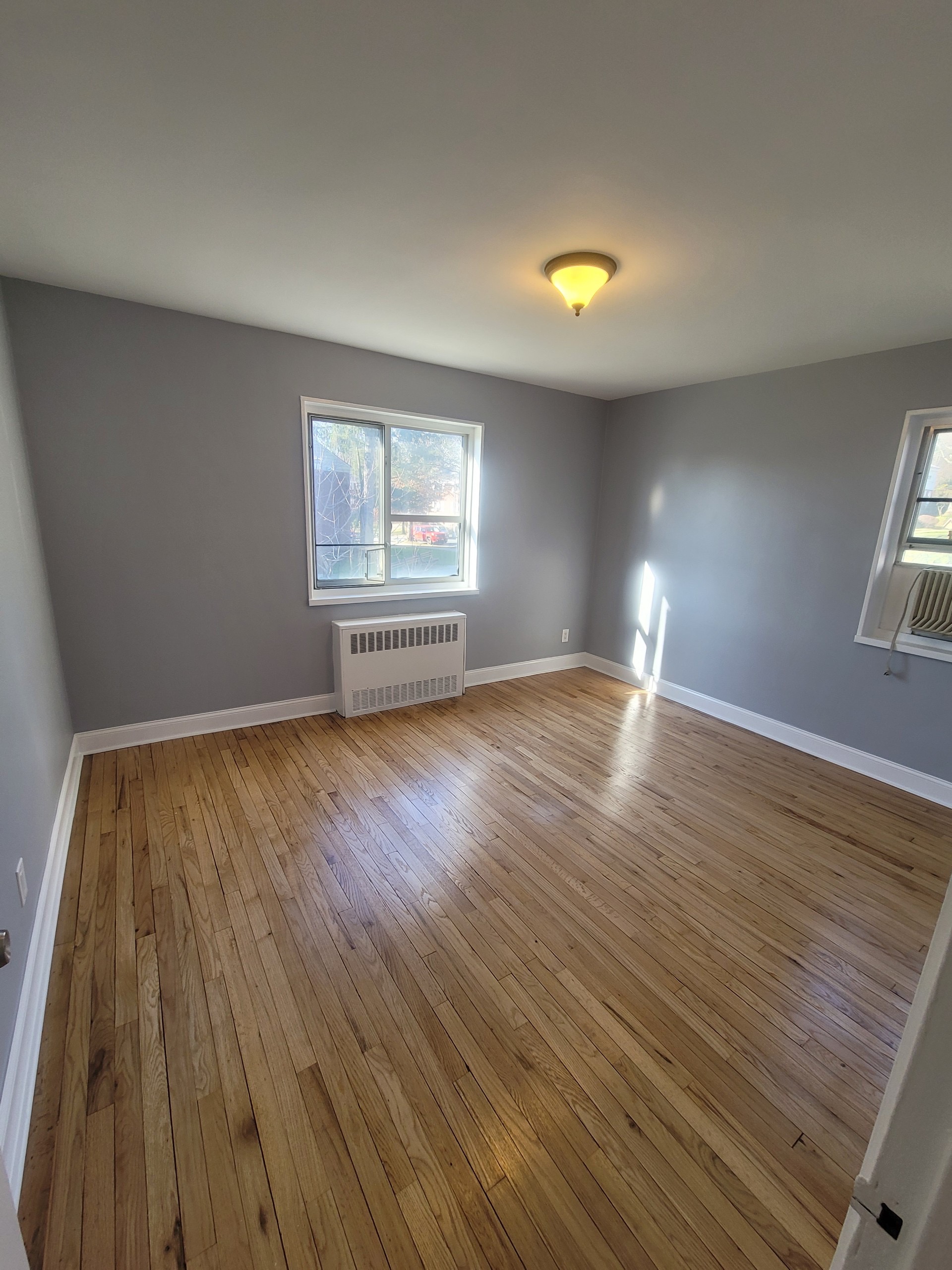 224-24 Manor Road, Unit U Queens, NY 11427 - Photo 7 of 10 a view of empty room with wooden floor and fan