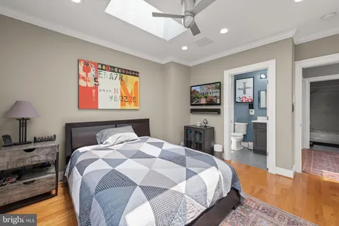 a spacious bedroom with a bed and a flat screen tv