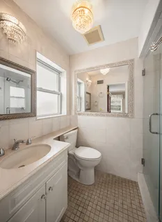 a bathroom with a sink a toilet a mirror and a window