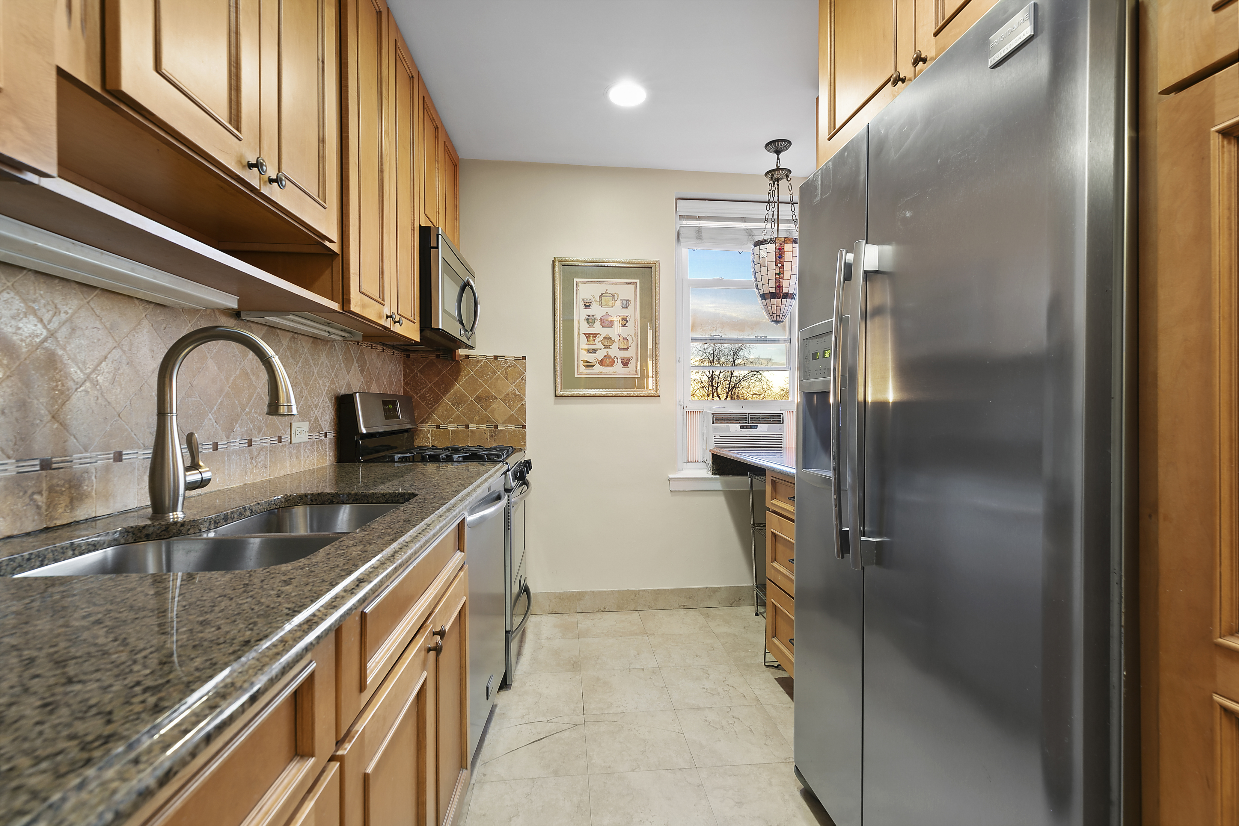 9801 Shore Road, Unit 5A Brooklyn, NY 11209 - Photo 6 of 11 a kitchen with stainless steel appliances granite countertop a sink and a refrigerator
