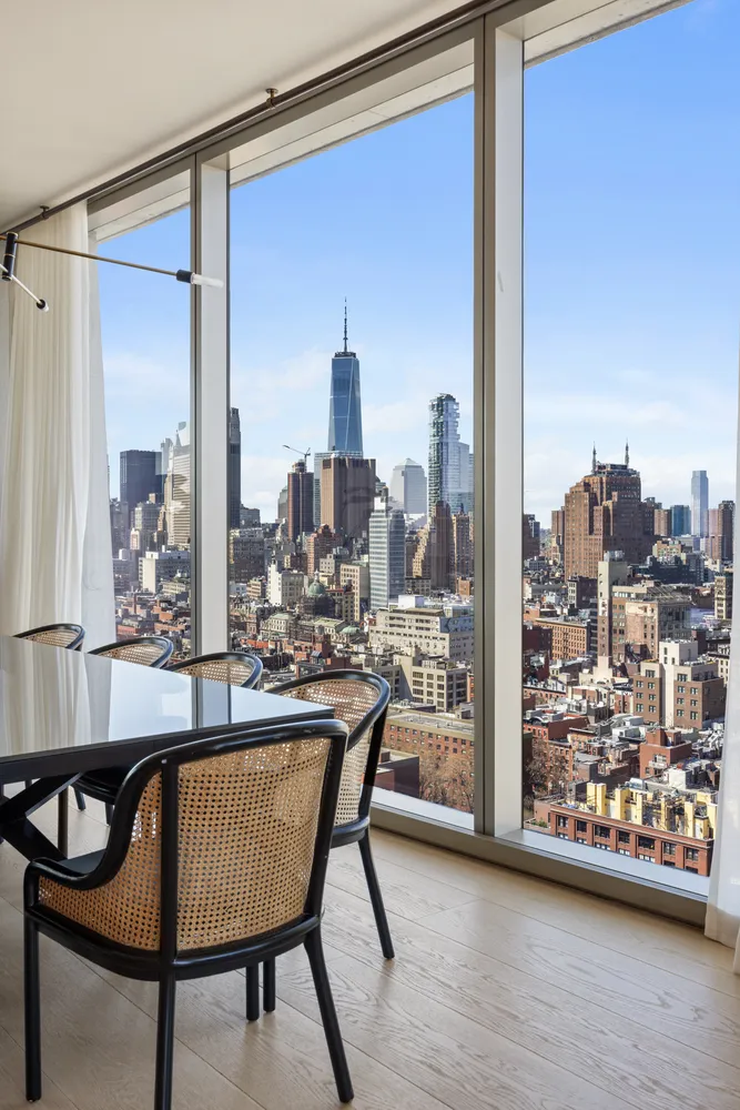 a dining table with chairs and view of living room