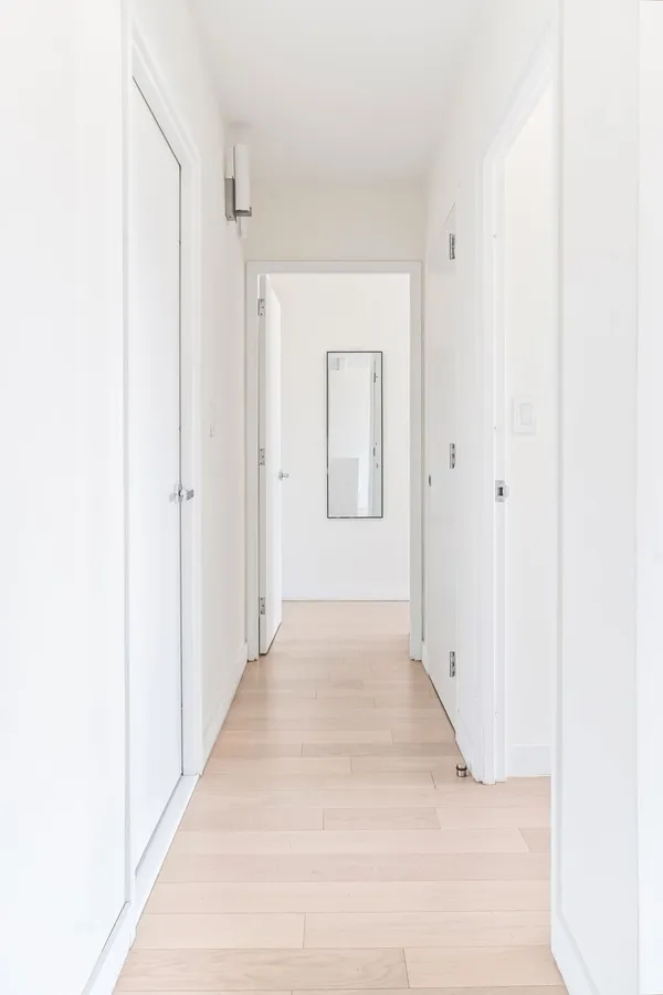 a view of a hallway with wooden floor