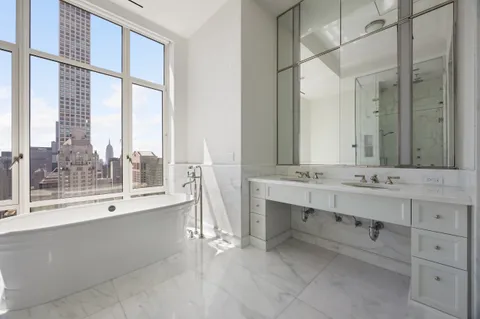 a bathroom with a tub sink and mirror
