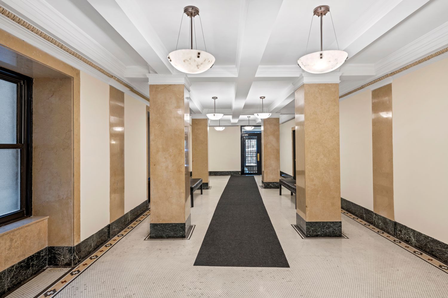 a view of a hallway with windows and chandelier