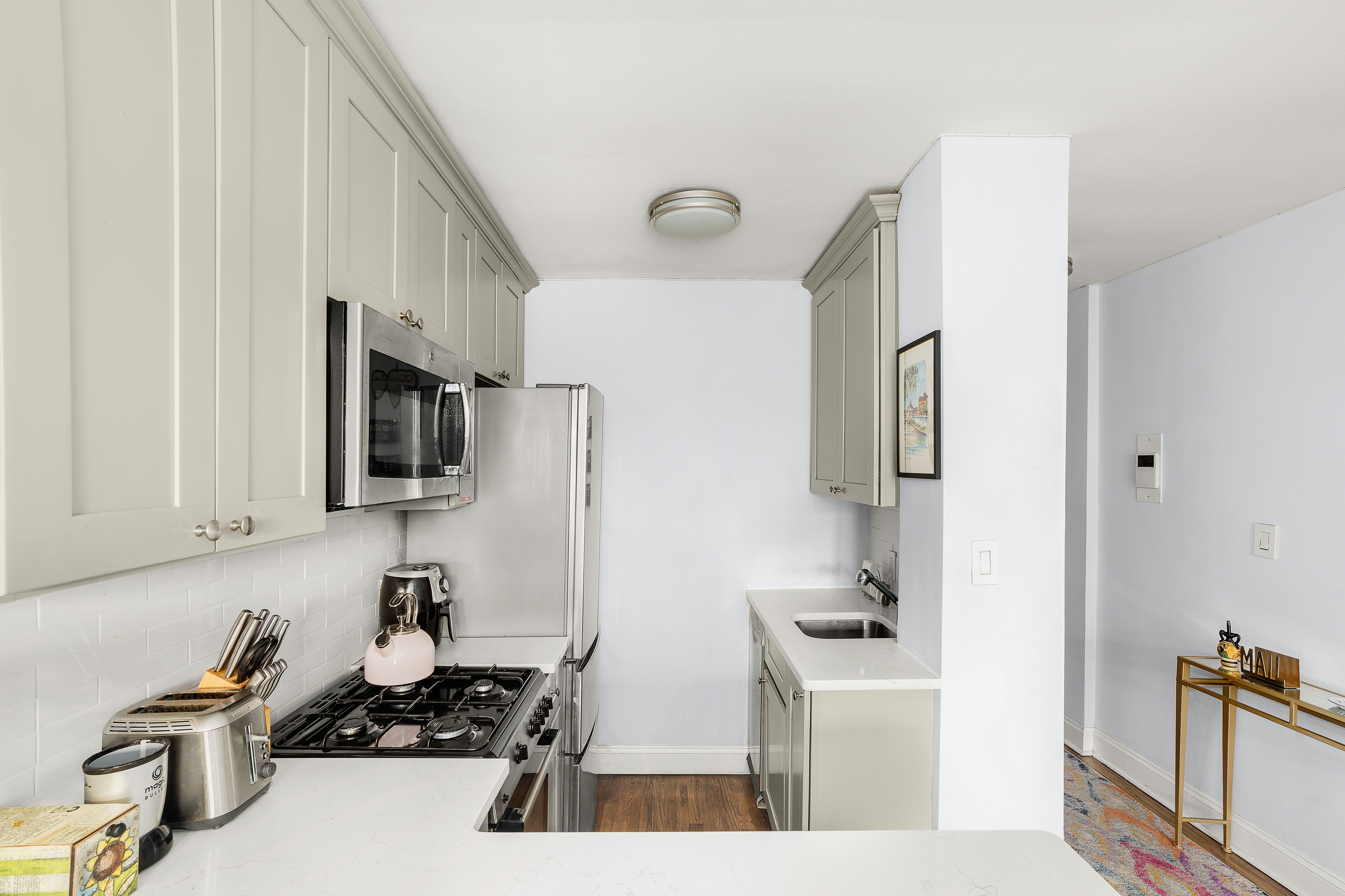 311 East 75th Street, Unit 4K Manhattan, NY 10021 - Photo 4 of 8 a kitchen with stainless steel appliances a sink a stove and a refrigerator