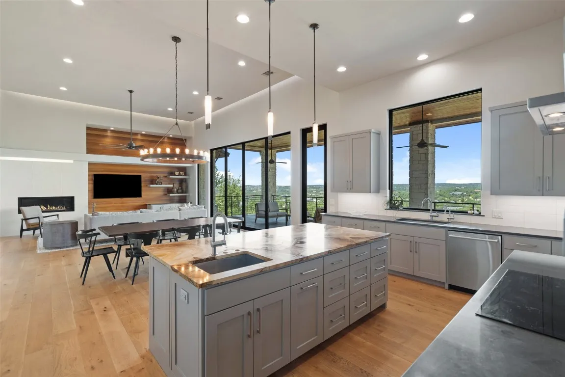 a living room with stainless steel appliances kitchen island furniture and a large window