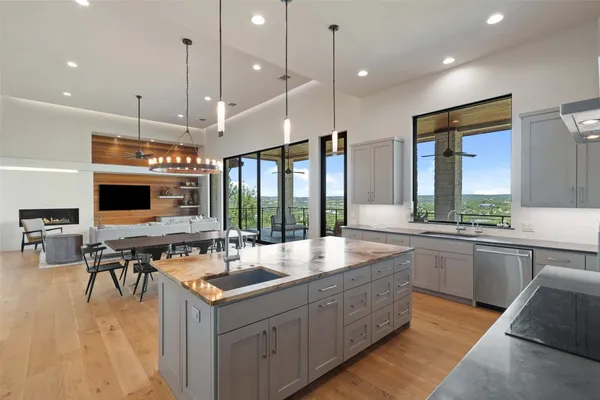 a living room with stainless steel appliances kitchen island furniture and a large window