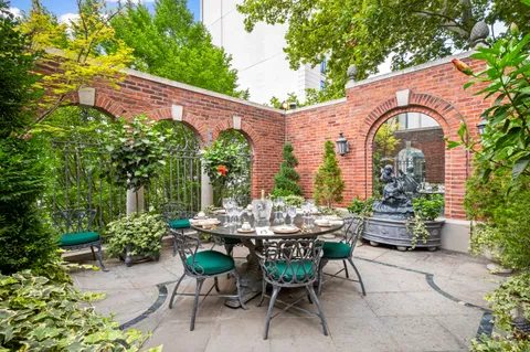 a bedroom with a bed a mirror on dresser and a window