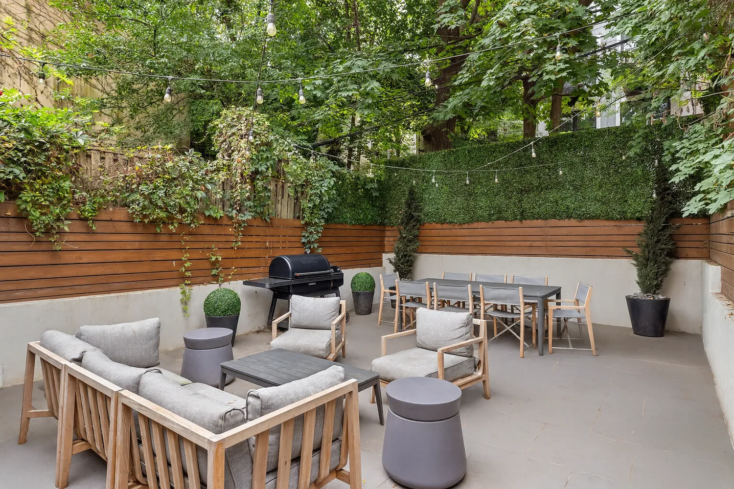 a view of a patio with couches table and chairs and potted plants