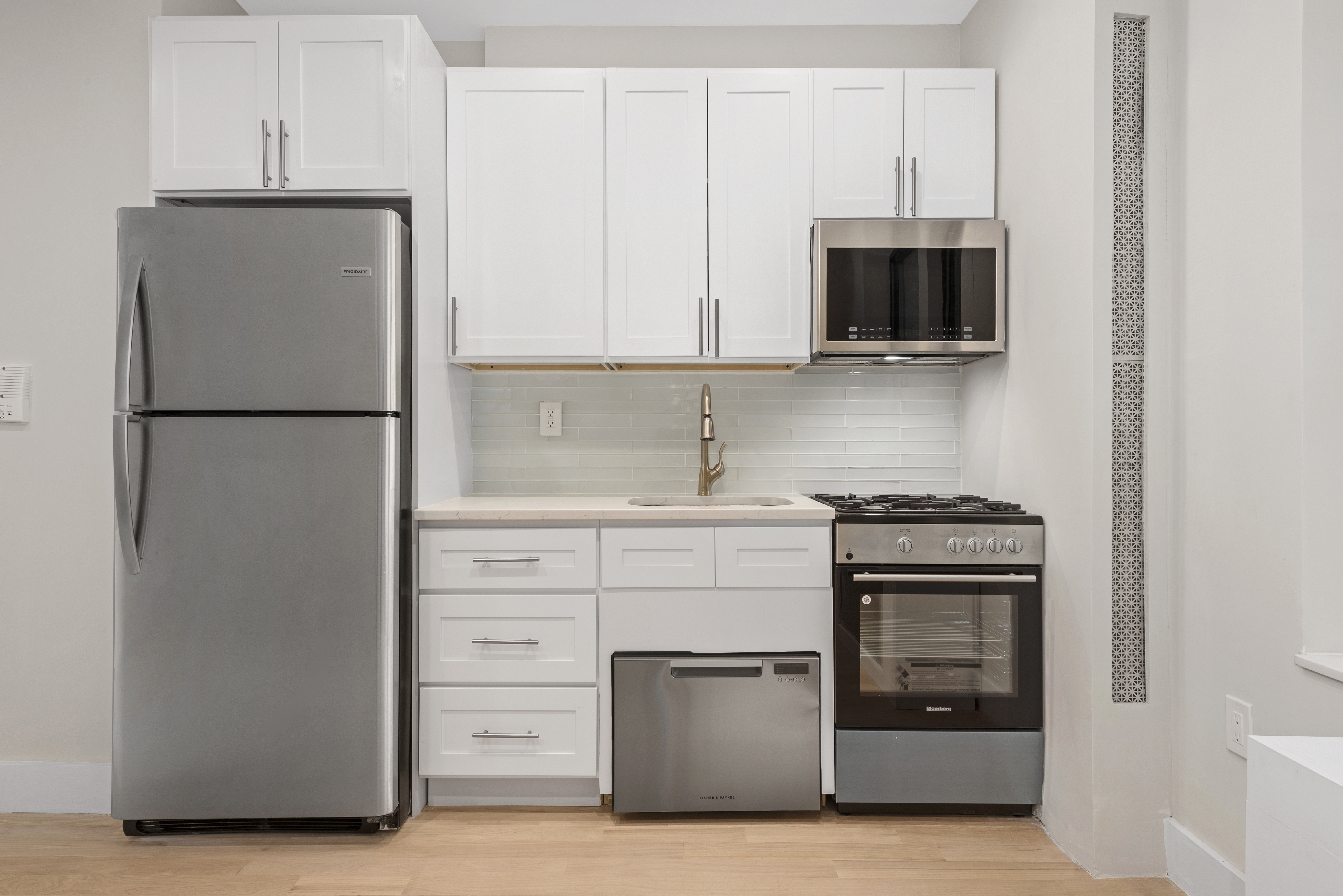 750 Riverside Drive, Unit 3B Manhattan, NY 10031 - Photo 2 of 6 a kitchen with white cabinets and stainless steel appliances