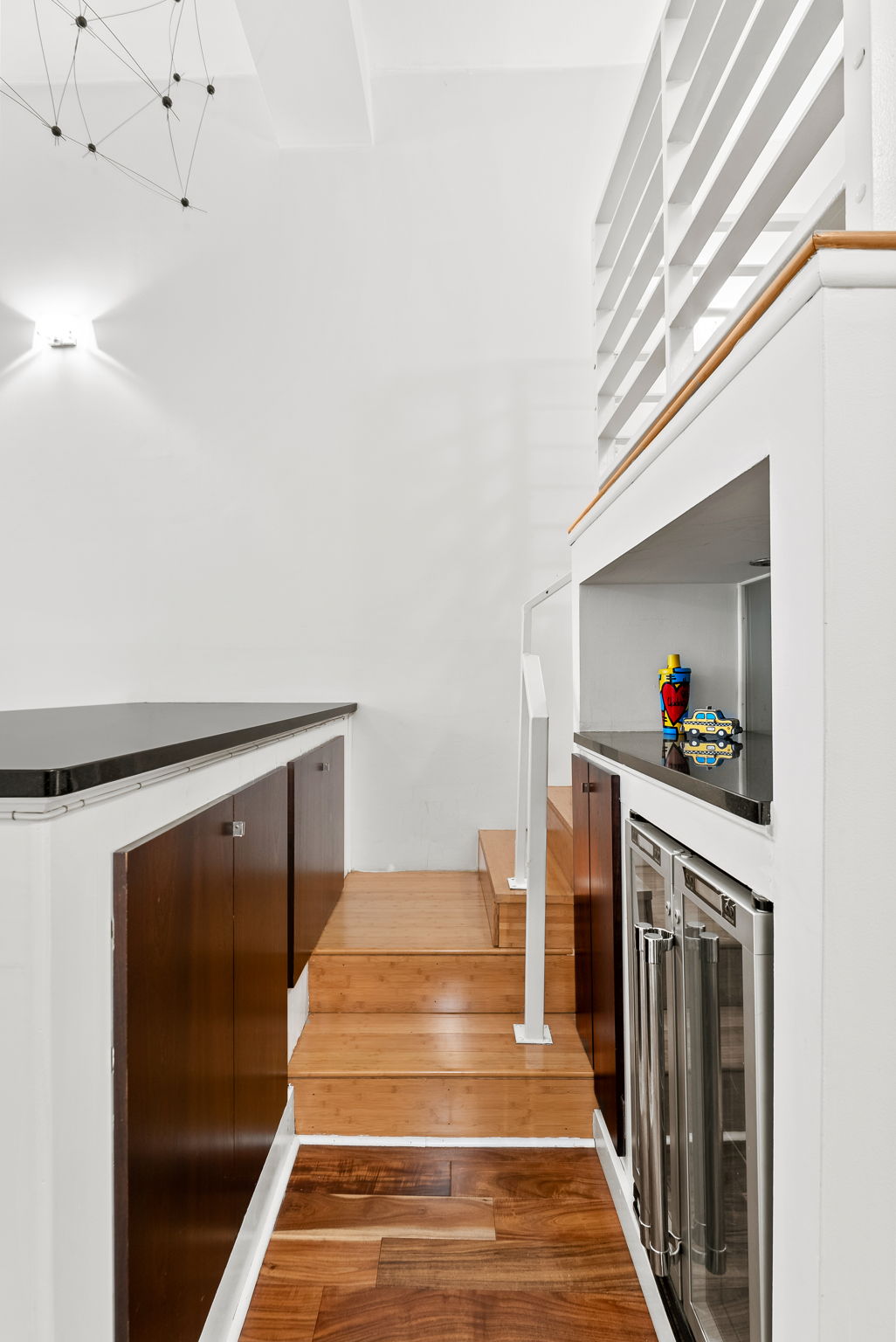 310 East 46th Street, Unit 5T Manhattan, NY 10017 - Photo 4 of 13 a hallway with white cabinets and black stainless steel appliances