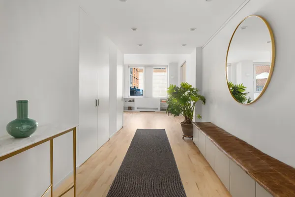 a view of a hallway with wooden floor and a potted plant