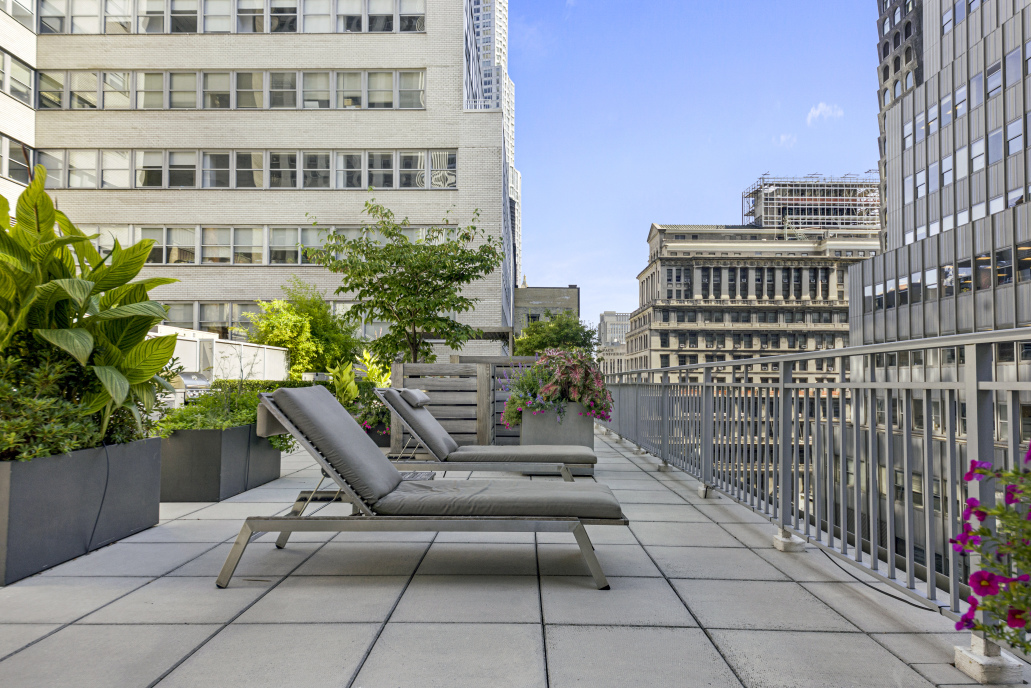 59 John Street, Unit 4H Manhattan, NY 10038 - Photo 17 of 19 a roof deck with couple of chairs and wooden fence
