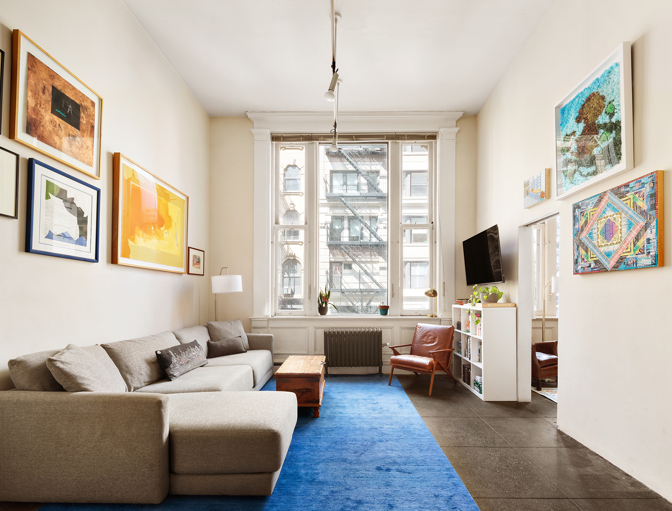 90 West Broadway, Unit 2B Manhattan, NY 10007 - Photo 2 of 12 a living room with furniture and a flat screen tv