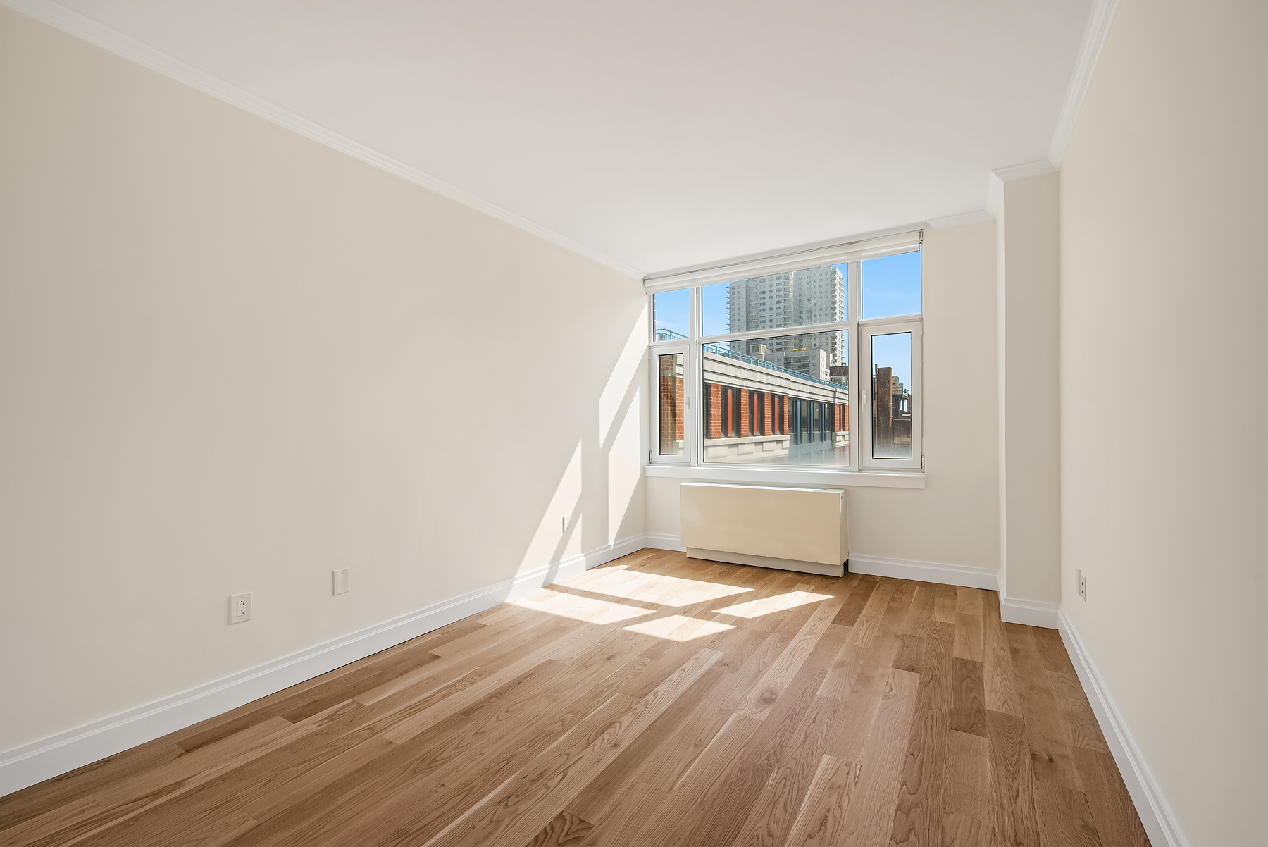 404 East 76th Street, Unit 7C Manhattan, NY 10021 - Photo 6 of 13 a view of an empty room with wooden floor and a window
