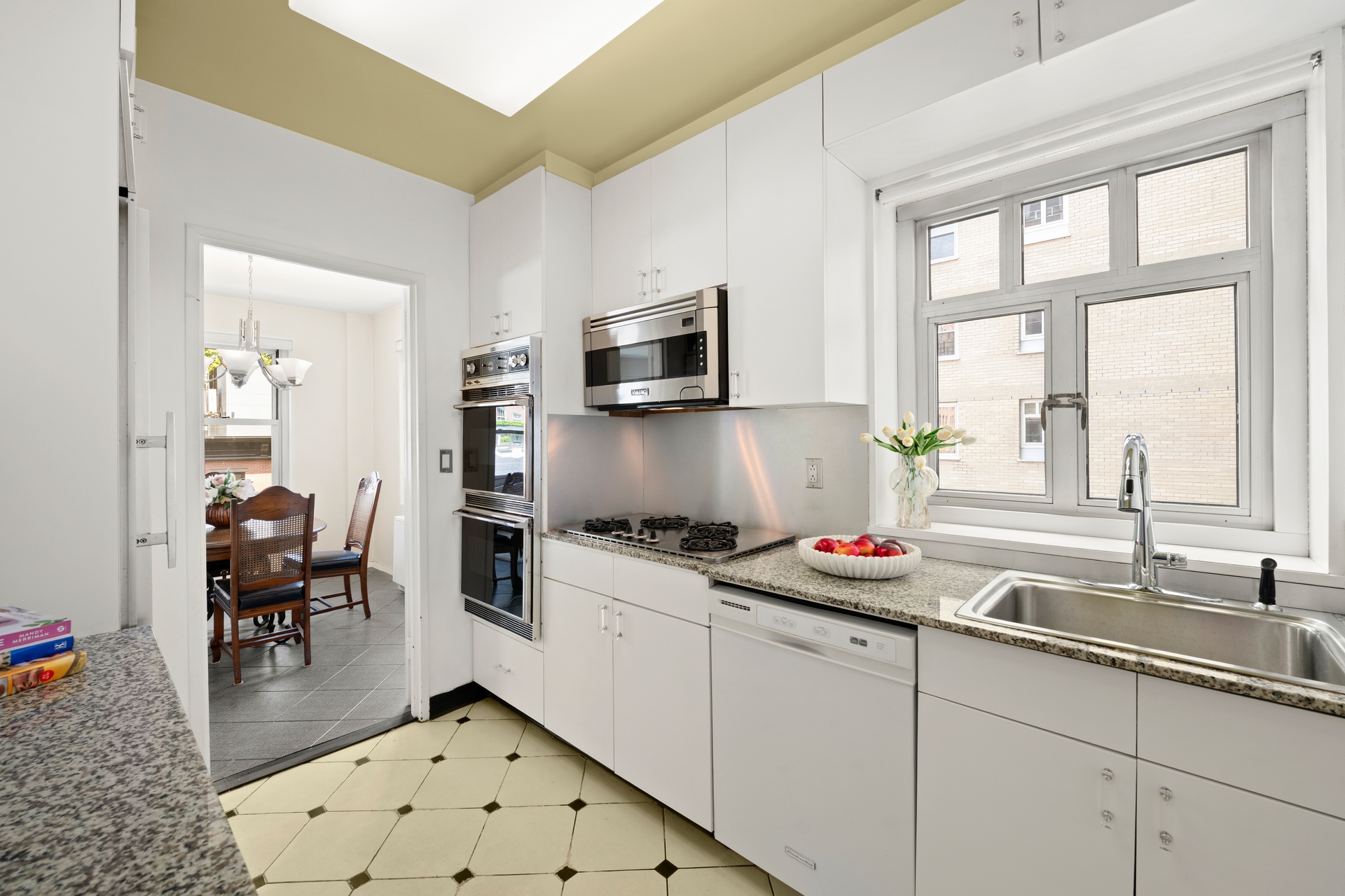 20 East 9th Street, Unit 7V Manhattan, NY 10003 - Photo 8 of 30 a kitchen with granite countertop a sink stove and cabinets