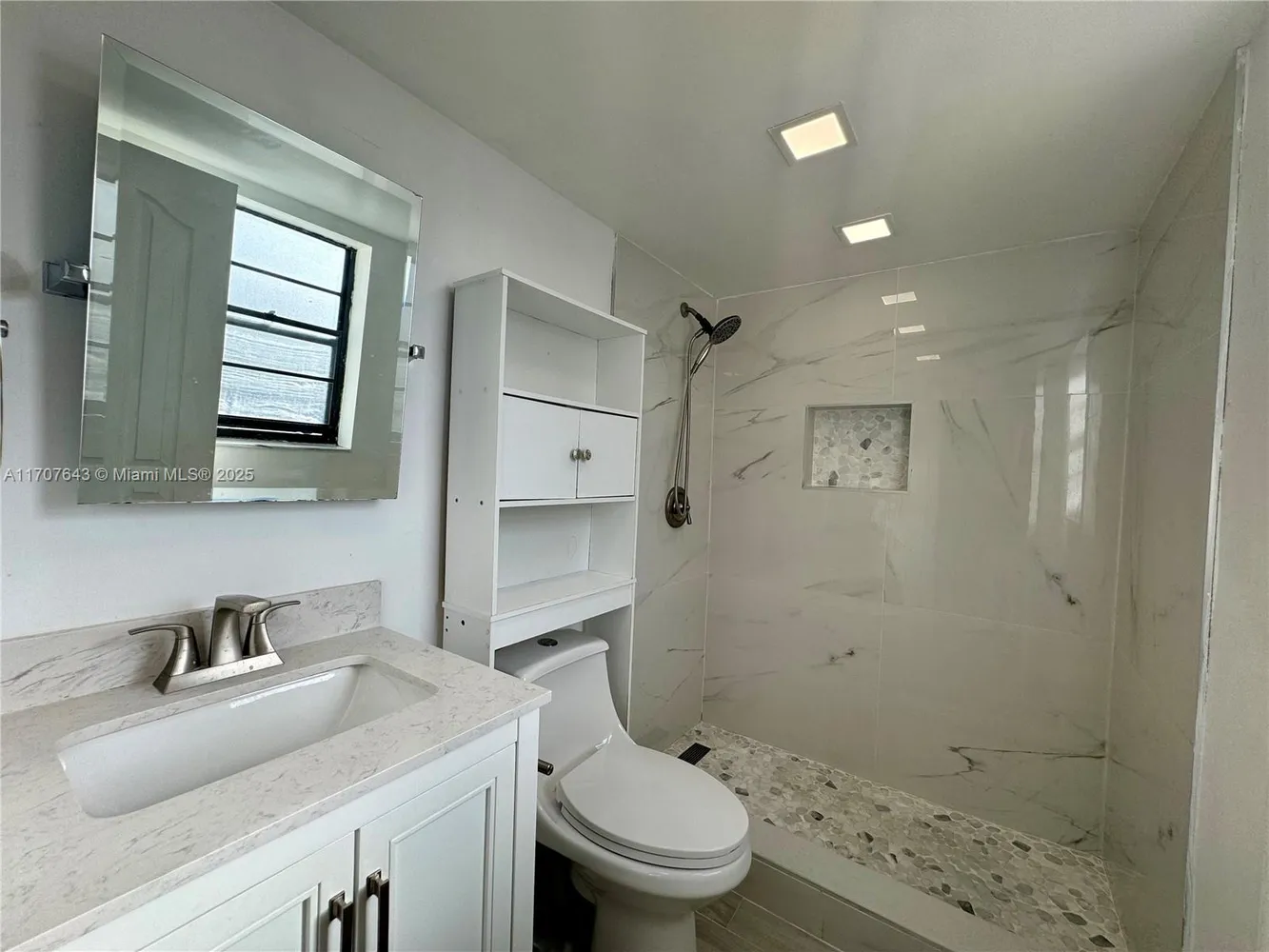 a bathroom with a granite countertop sink a toilet and shower
