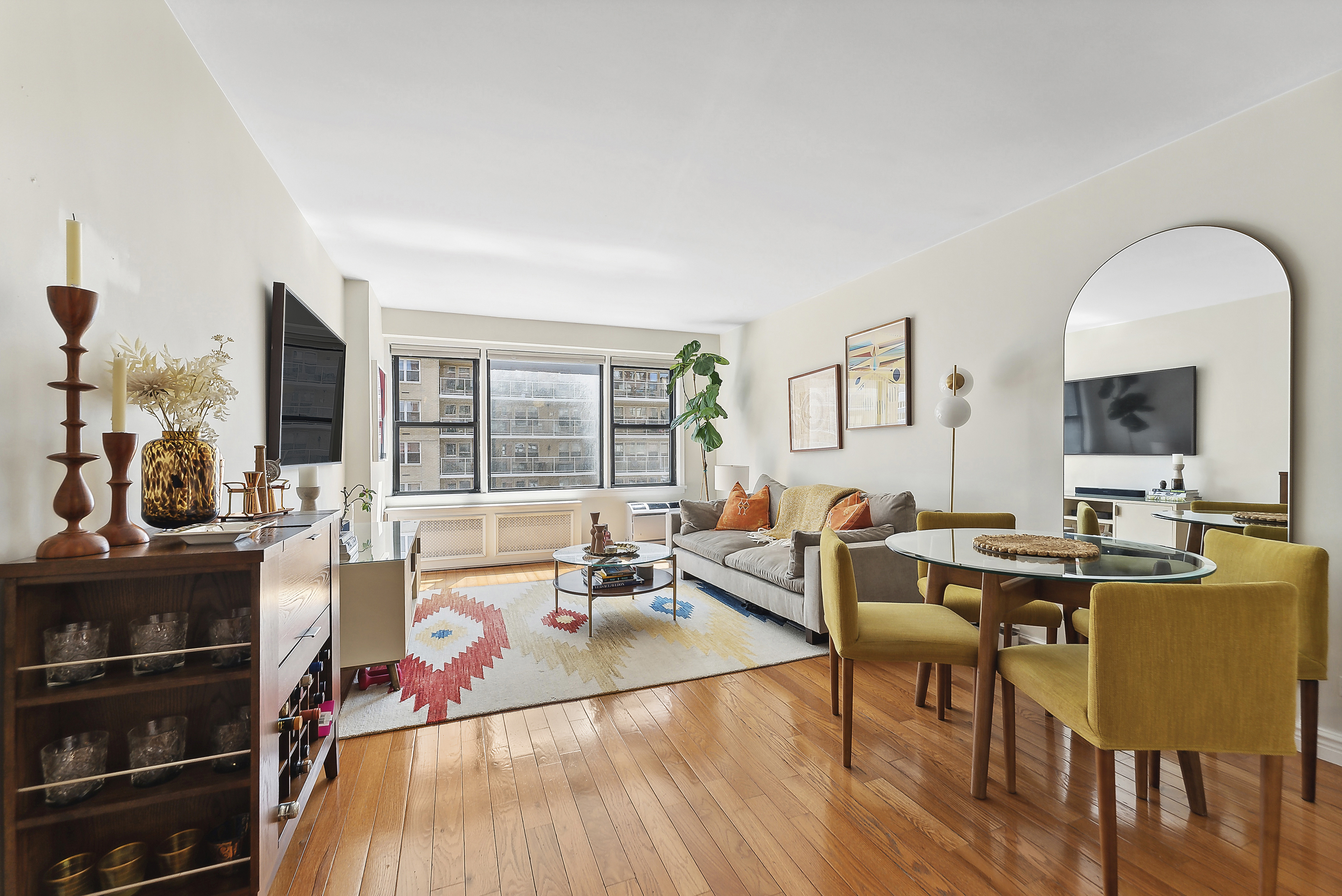 245 East 24th Street, Unit 10D Manhattan, NY 10010 - Photo 1 of 6 a living room with furniture a flat screen tv and a table