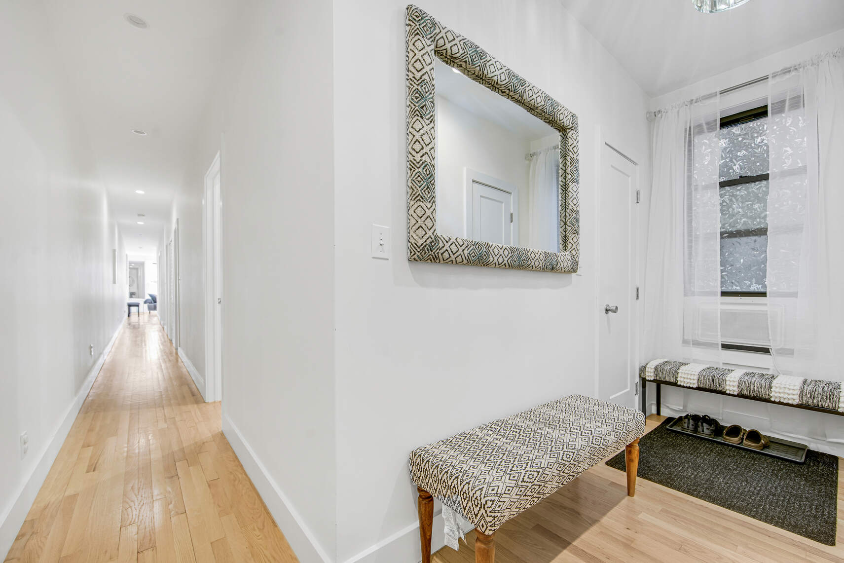1878 Adam Clayton Powell Jr Boulevard, Unit 52 Manhattan, NY 10026 - Photo 7 of 13 a hallway with a couch and wooden floor
